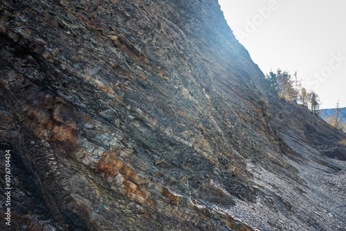 Close-up of layered sedimentary rock formations with diverse textures and natural color tones. Perfect for geology, nature, and abstract backgrounds. Captures rugged, weathered details of ancient ston photo