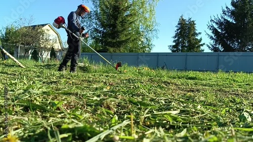 a man mows the grass in the garden.