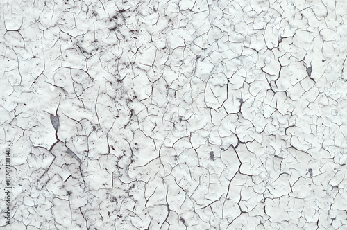 Peeling paint on the wall. Old concrete wall with cracked flaking paint, closeup of cracks and fissures of peeling paint
