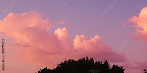 A pink sunset illuminating fluffy clouds in a purple sky