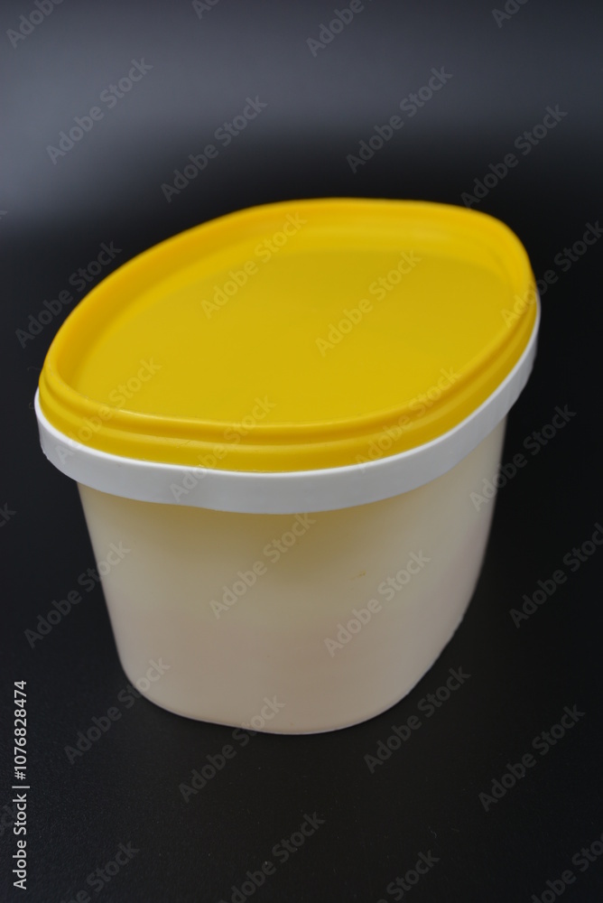 All household items, a plastic white container, containers for food and food are located on a black matte background. All household items, a plastic white container, containers for food and food are located on a black matte background.