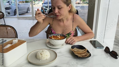 A woman is relishing a delightful meal and drinks in a modern cafe  photo