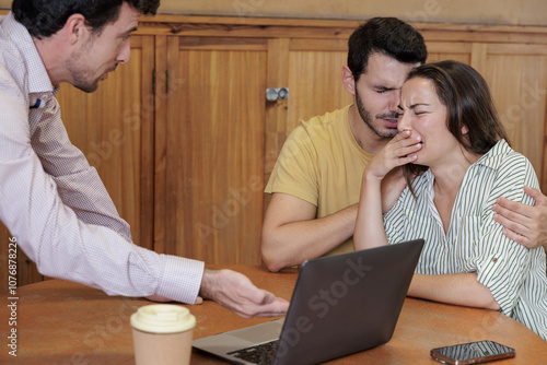 A young teacher brings parents together to explain their child's situation at school. Some parents are very upset and cry with the bad news that the teacher is telling them. photo