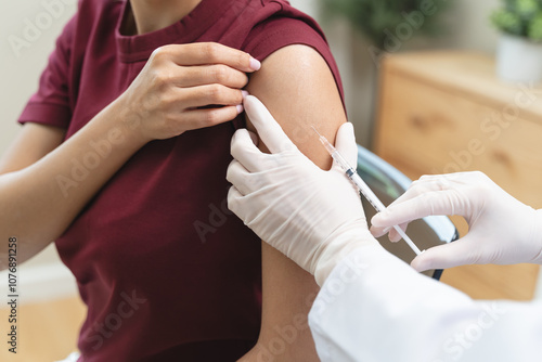 People getting a vaccination to prevent pandemic concept. Woman in medical face mask  receiving a dose of immunization coronavirus vaccine from a nurse at the medical center hospital