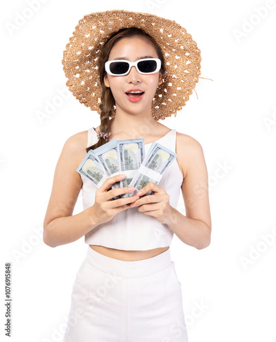 A joyful woman holding money, wearing sunglasses and a straw hat, posing fashionably against a white background. photo