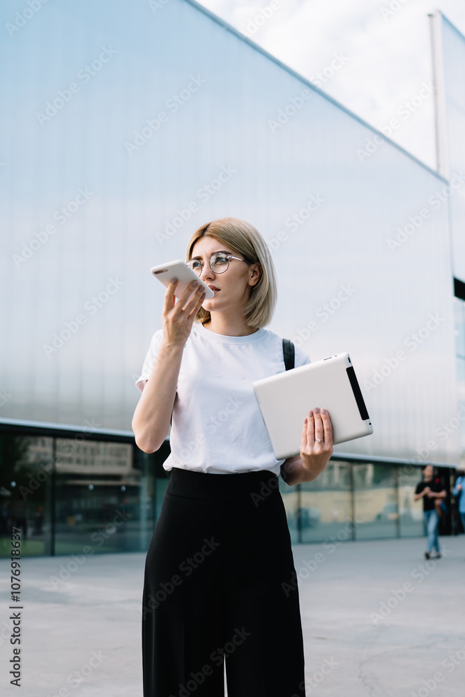 Pensive woman talking on smartphone on city street