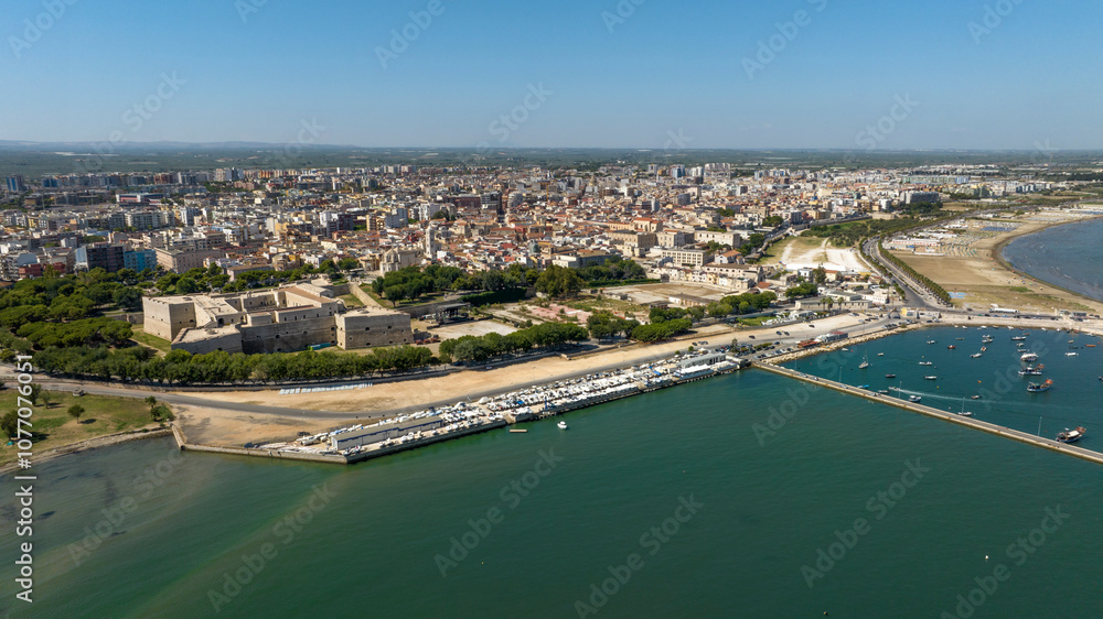 Fototapeta premium Aerial view of the castle located in Barletta, Puglia, Italy. It was a medieval fortress built for defense and today it is a museum. There is a park around the fort. In foreground is the Adriatic sea.