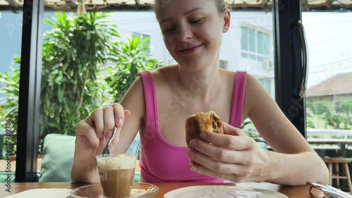 A woman is relishing a delightful meal and drinks in a modern cafe  photo