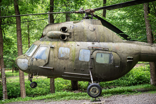 Old helicopter against the background of a forest.