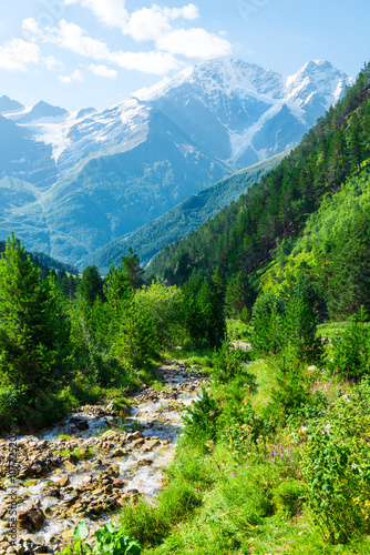 Beautiful mountain landscape in the valley of the stormy clean river Terskol with a view of the glacier 