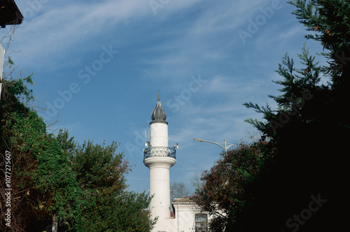 Stunning minaret against clear blue sky and green trees in çengelköy istanbul, turkey photo