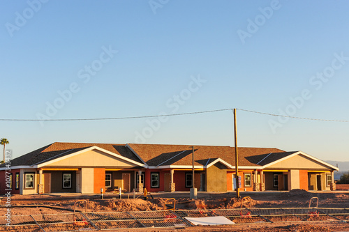 Overview of a set of newly built townhomes in the final stages of construction in a subdivision in Pinal County, Arizona photo