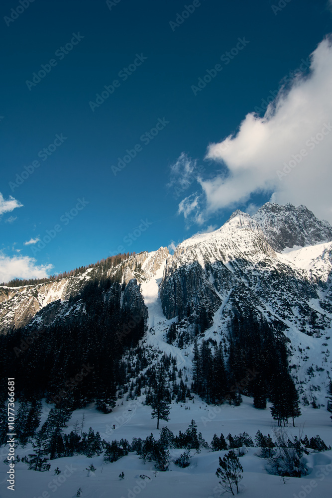 Obraz premium Snowy mountain landscape with clear blue sky and clouds in the winter