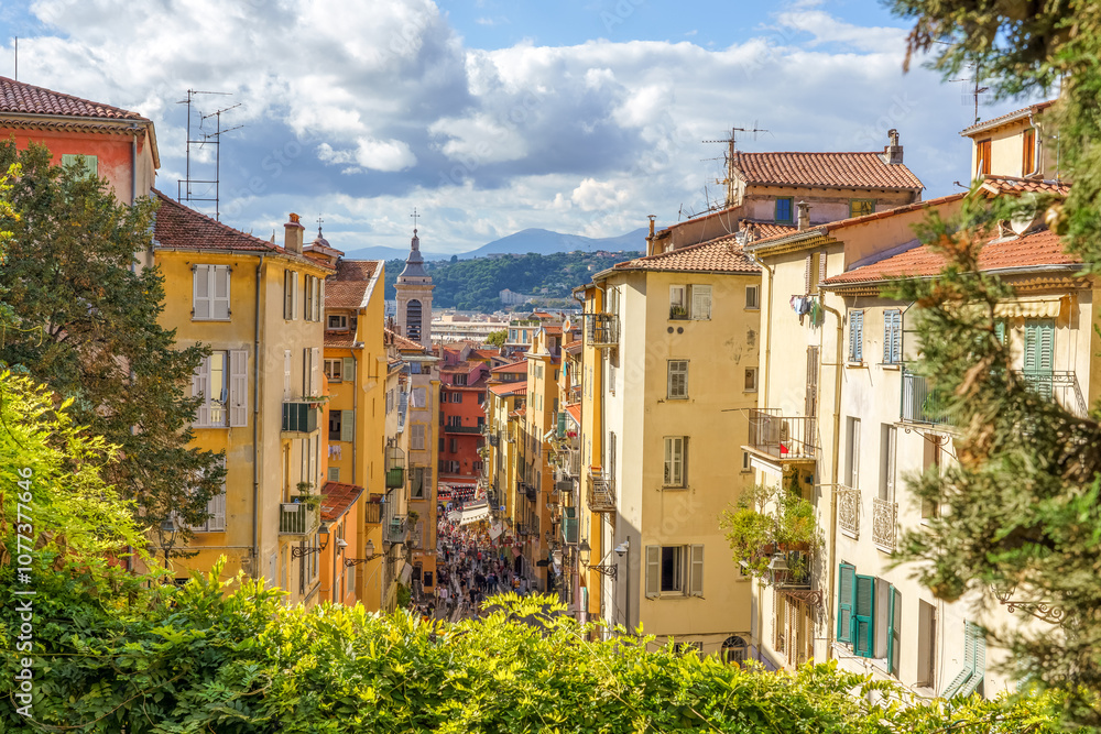 Nice, France. Upside view to the crowded narrow street in the old town, mountains in the background. Nice, France. Upside view to the crowded narrow street in the old town, mountains in the background.