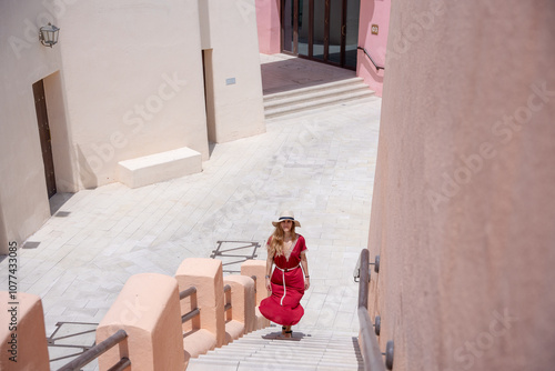 girl with a red dress walking on the Colorful Streets in Mina District Corniche, Doha Marina, Doha, Qatar photo