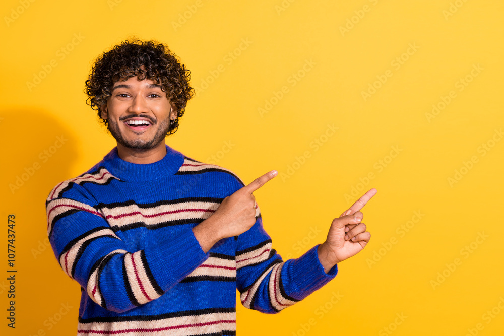 Photo portrait of pretty young male point empty space wear trendy blue striped outfit isolated on yellow color background Photo portrait of pretty young male point empty space wear trendy blue striped outfit isolated on yellow color background