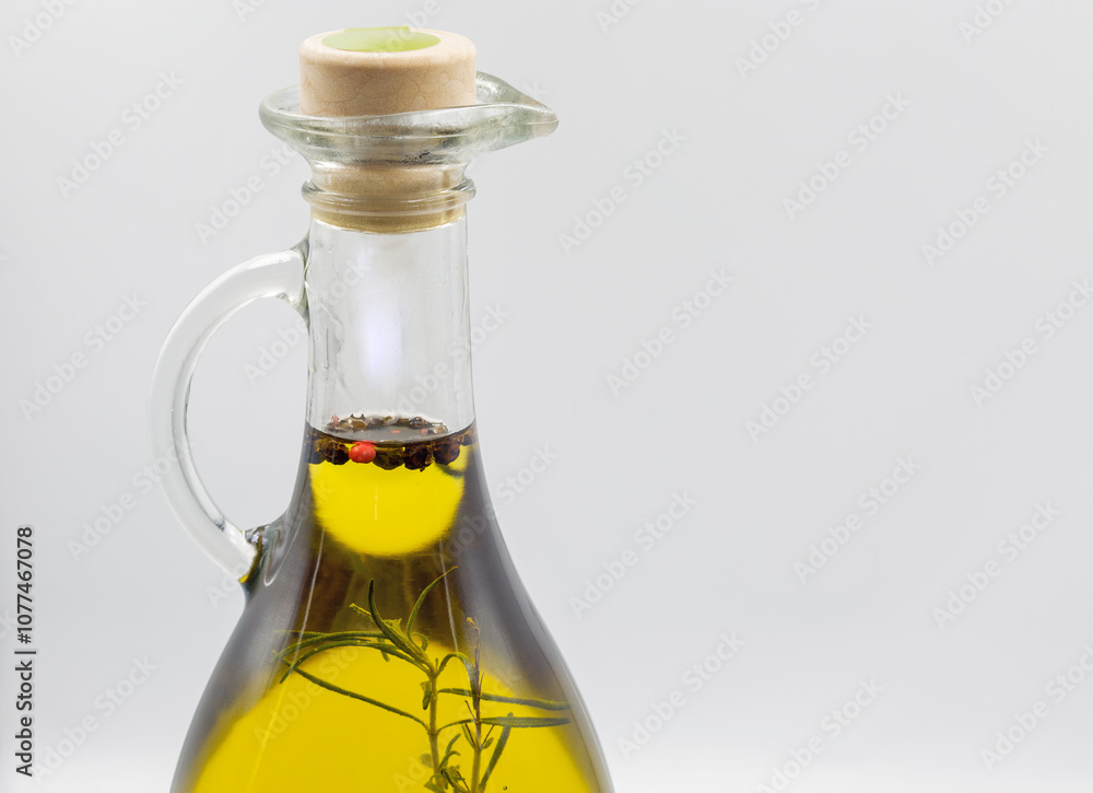Transparent bottle of olive oil with herbs and seeds closeup. Transparent bottle of olive oil with herbs and seeds closeup.