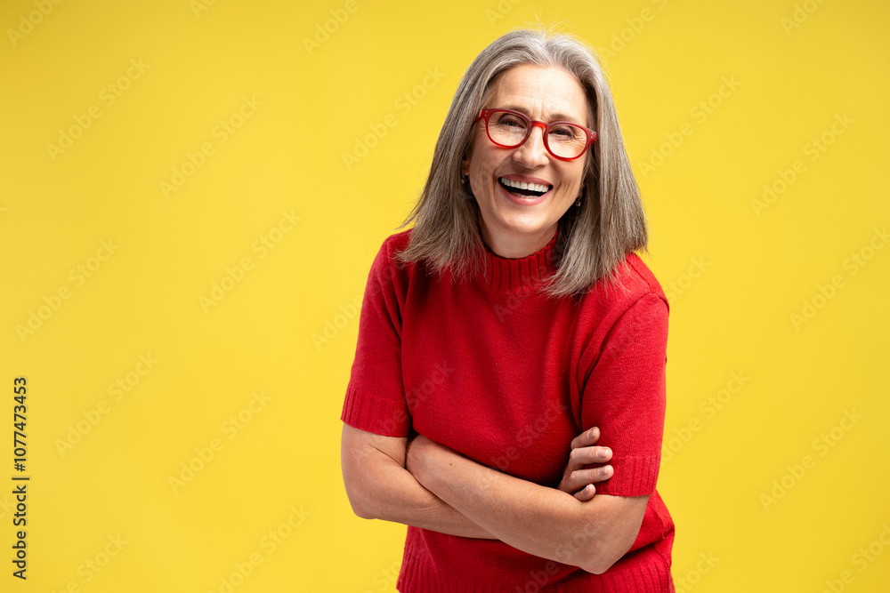 Beautiful, smiling senior woman wearing stylish eyeglasses and red sweater with crossed arms Beautiful, smiling senior woman wearing stylish eyeglasses and red sweater with crossed arms