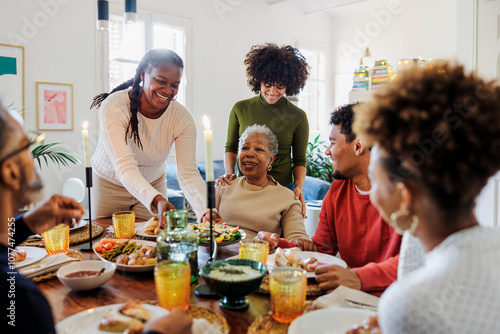 Happy family is sitting at the table and having dinner together photo