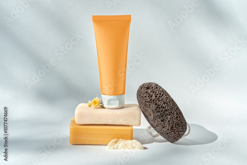 Modern still life with cosmetic tube, soap, flowers and pumice stone. photo