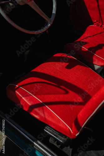 Vintage car interior with vibrant red seats and shadows photo