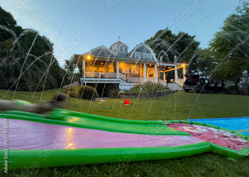 Backyard House  Summer fun on water slide on hot summer day photo