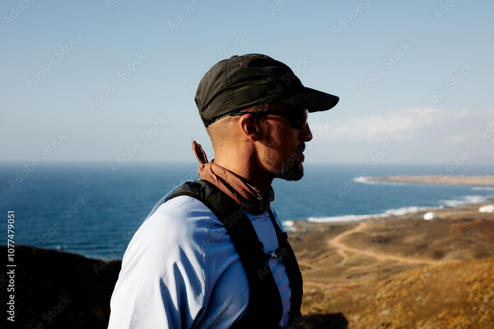 Man in activewear admiring the landscape from the summit of a volcano Man in activewear admiring the landscape from the summit of a volcano