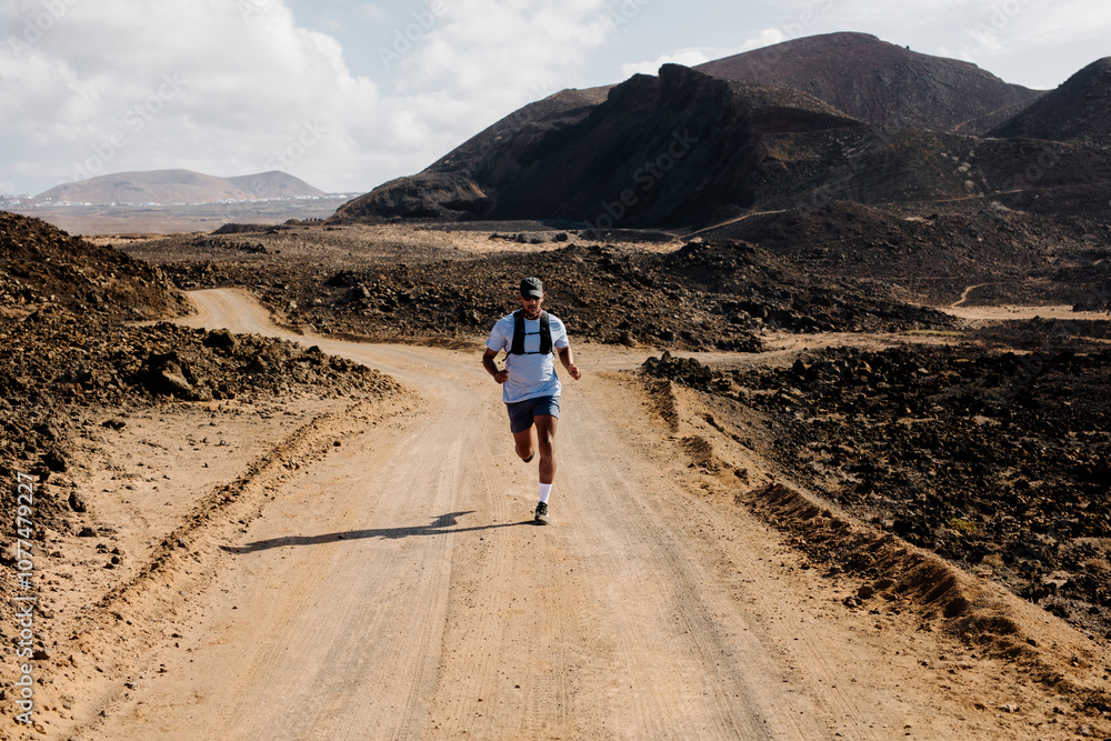Man hiking through the volcanic landscapes of the Timanfaya Park Man hiking through the volcanic landscapes of the Timanfaya Park