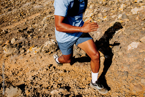 Body of an unknown athlete jogging uphill during trail running workout photo