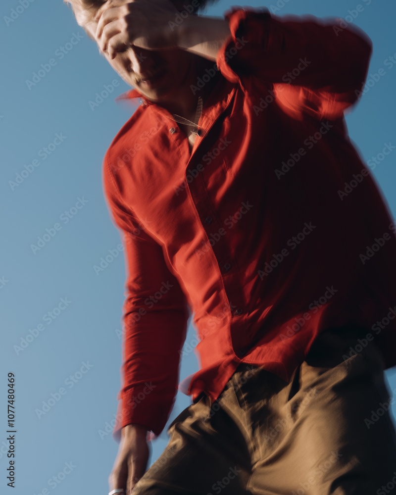 Man in Red Shirt Against Clear Blue Sky in Motion Man in Red Shirt Against Clear Blue Sky in Motion