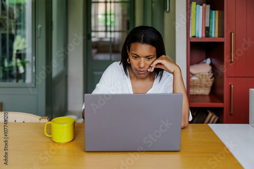 Focused woman working from home having issues with laptop photo