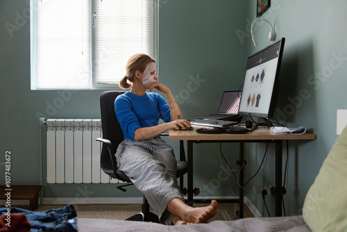 Woman browsing online store while wearing a facial mask photo