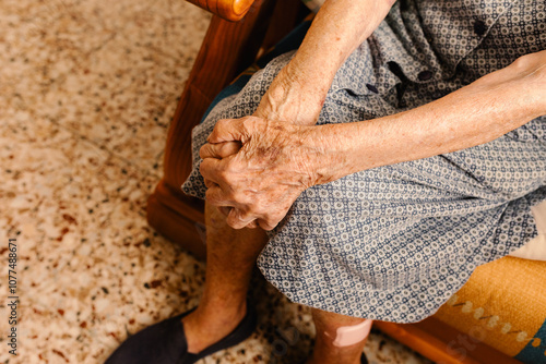 Detail of deep lines on the unidentified elderly's skin crossing arms photo