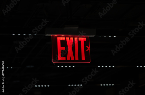 Red exit sign illuminated against dark background photo