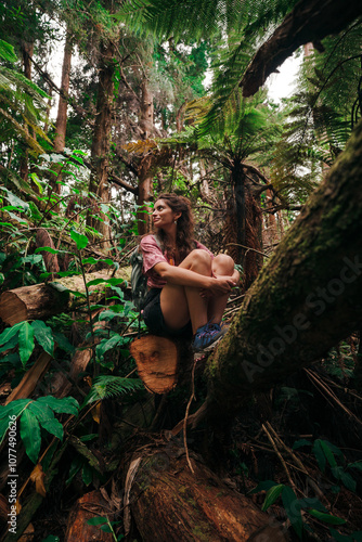 Explorer woman sitting in green wild forest photo