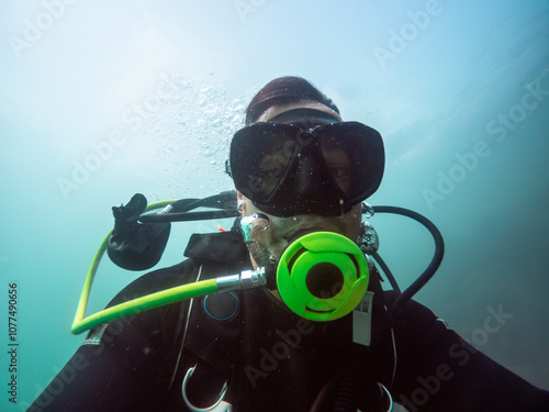 Diver wearing scuba gear taking underwater selfie photo