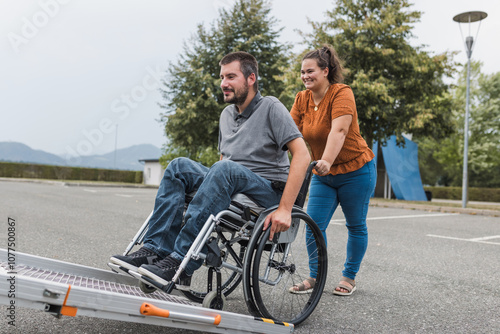Принти на полотні Smiling woman, a personal caregiver assisting a man with a disability in entering the adaptive vehicle with an accessible ramp