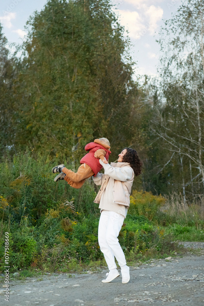 Mother lifting son in the air during outdoor playtime Mother lifting son in the air during outdoor playtime