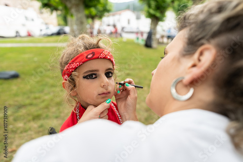 Makeup artist applying face paint on boy outdoors photo