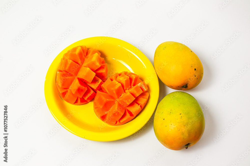 Whole and sliced mango in yellow plate isolated on white background, fresh orange mango Whole and sliced mango in yellow plate isolated on white background, fresh orange mango