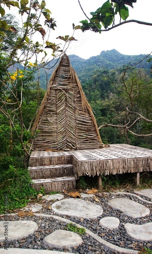 photo of a saung, or simple hut made of wood and with a beautiful thatched roof, in the park photo