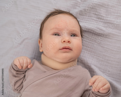 Top view of a newborn baby wearing an orthopedic collar. photo