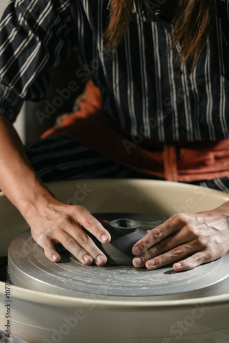 Creating clay pottery on a wheel in a workshop setting photo