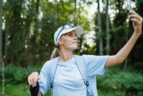 A woman is talking on a video chat in the forest photo