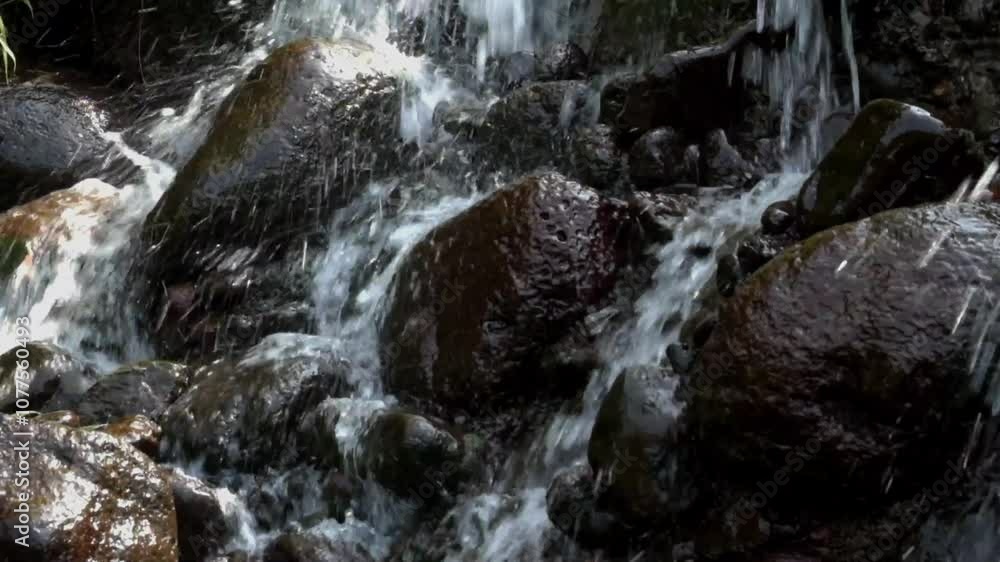 Small waterfall with clear water flowing through natural rocks. Looks calm and peaceful, suitable for relaxation. Natural water source. Real time, raw video no edit. Footage 4K,60Fps Small waterfall with clear water flowing through natural rocks. Looks calm and peaceful, suitable for relaxation. Natural water source. Real time, raw video no edit. Footage 4K,60Fps