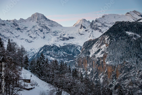 Obraz na płótnie Scenic view of Lauterbrunnen Valley, Switzerland seen from Wengen with snowcovered mountains with Breithorn (left) and Tschingelhorn (right) in winter against blue sky at sunset w salonie