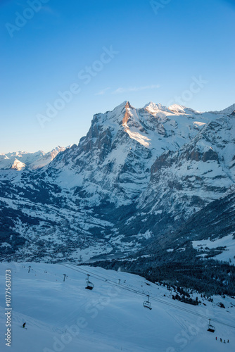 Obraz na płótnie Scenic view of Grindelwald, Switzerland with snowcovered Wetterhorn mountain in winter against blue sky early in the morning w salonie
