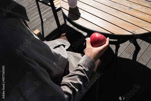Man holding an apple in cafe