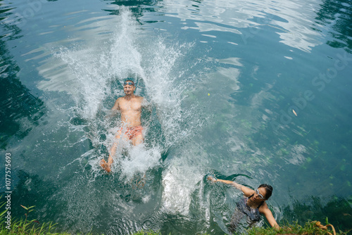 Man Making a Splash in a Blue Lagoon with Friend Nearby. photo