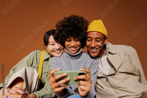 Three friends watching funny video on smartphone